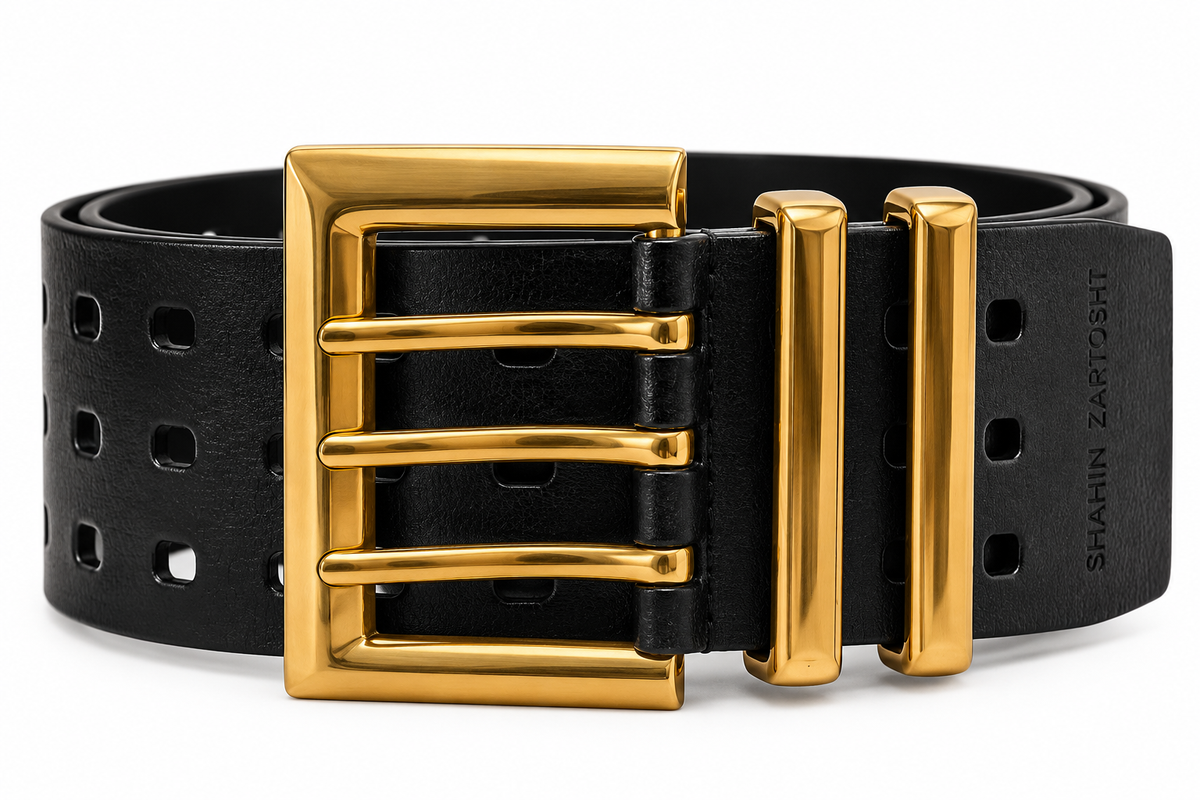 A black leather belt with a large, polished gold-tone buckle and matching gold-tone keeper loops, shown on a clean white background. The brand name 'SHAHIN ZARTOHT' is debossed on the side of the belt strap.